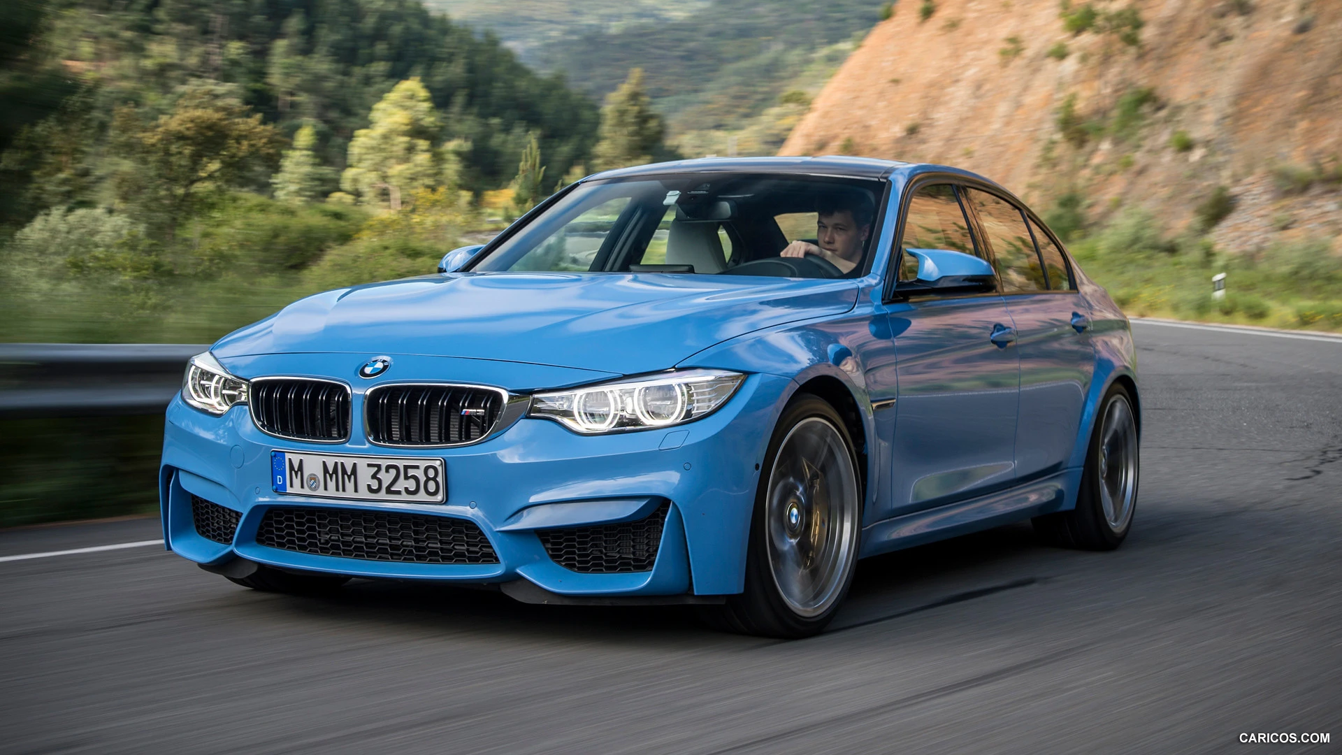 Blue F80 M3 driving on a mountain road
